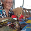 Photographer Lyn Pater looks over Helping Paws with Bertie Bear